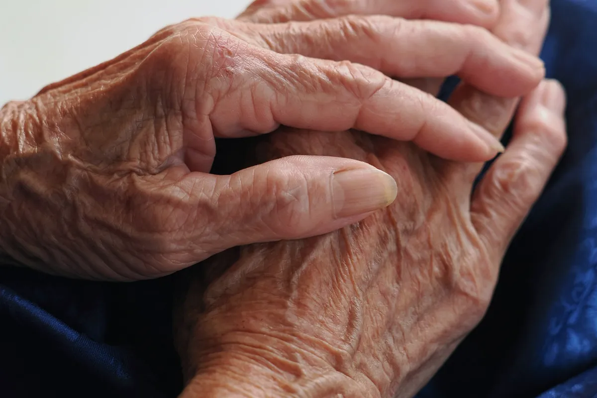 Mains âgées posées l’une sur l’autre